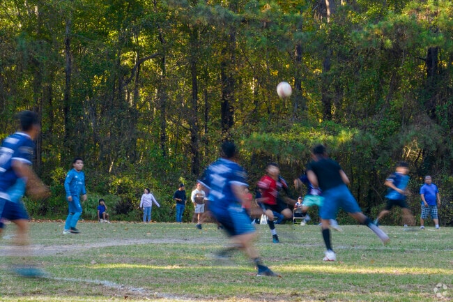 Adults play in a local soccer league game at Peach Road Park in South Raleigh.