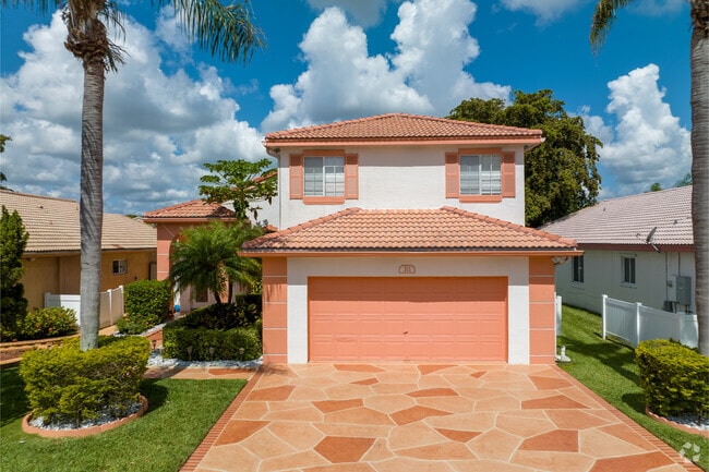 Admire the classic terracotta stamped front driveway of this Hillsboro Ranch home.