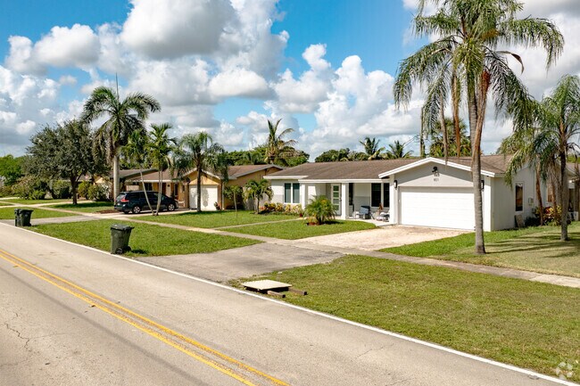 Plam trees surround this Street view of Simplistic Ranch Style Homes in Coconut Creek, FL.