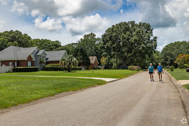 South Orchards residents enjoy an afternoon walk on a shady street.