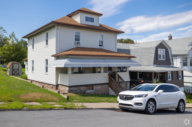 Front porches stretch close to the sidewalks, inviting neighborly interaction and street-level activity