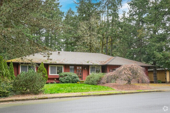 Red mid-century ranch home with lush landscaping in the neighborhood of West Beaverton.