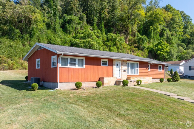 A cozy ranch-style home sits in a leafy neighborhood.