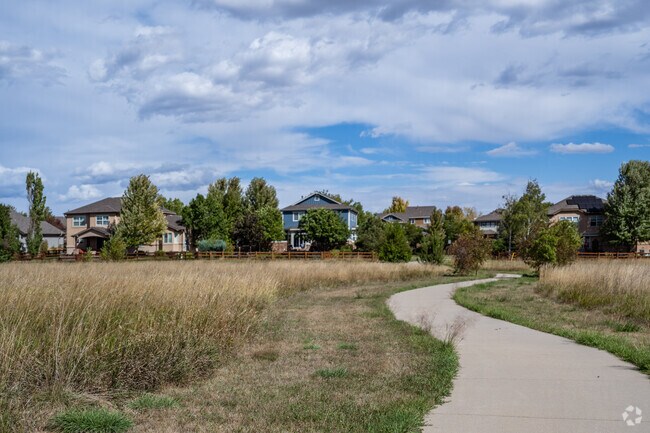 A paved path near homes weaves through open space near Aspen Creek.