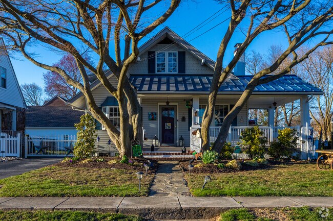 A craftsman home in Newport with unique trees lining the entry.