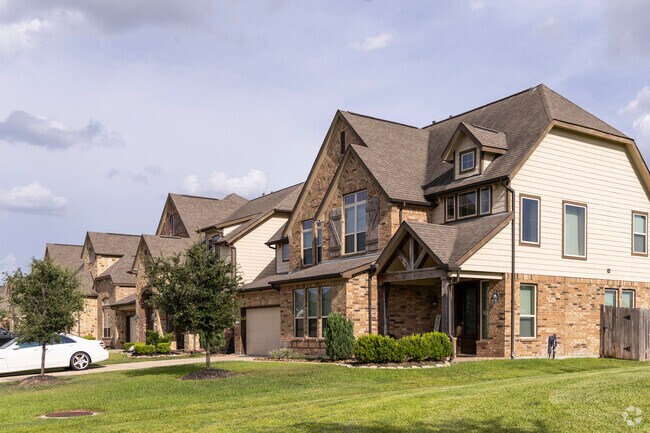 Large homes line the water's edge in The Lakes of Avalon Village in Klein Crossing.