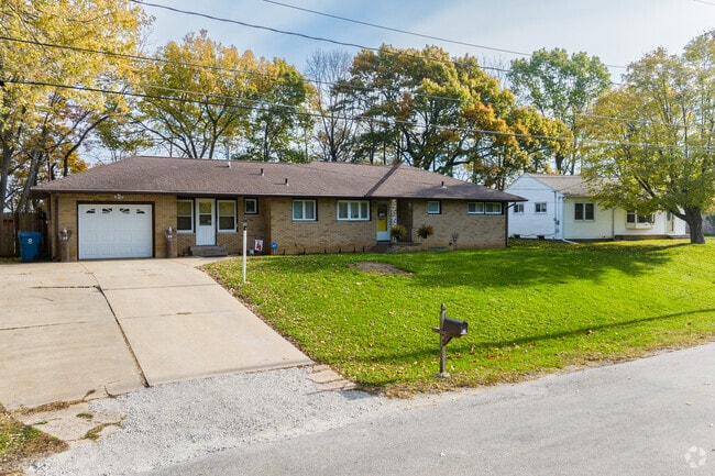 A view of a single-story home with brick siding.