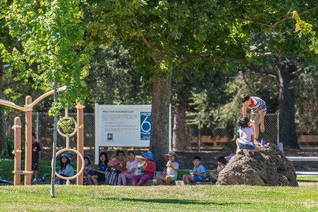 Kids at Wilson Park summer camp have a lunch break in the shade of the trees.