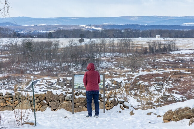 A tourist reads about the battle at Little Round Top at Gettysburg National Military Park.