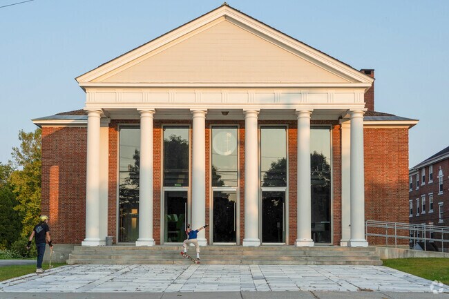 A pair of skaters practice their tricks on the steps of a VCFA building in College Hill.