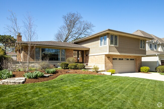 Split Level Style Home With Minimal Landscaping and Neutral Color Scheme Located in Springdale.