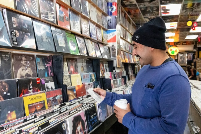 A customer reminisces over an album at Cow Records in Ocean Beach near Sunset Cliffs.