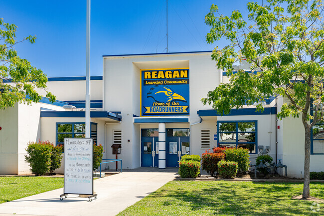 Students are greeted at the entrance to Reagan Elementary School by the school mascot.