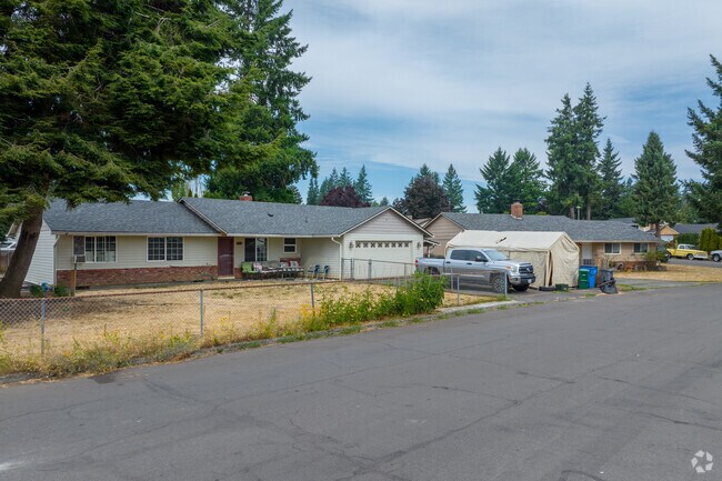 Ranch homes on NE 149th Ave in Parkside are bookended by large pine trees.