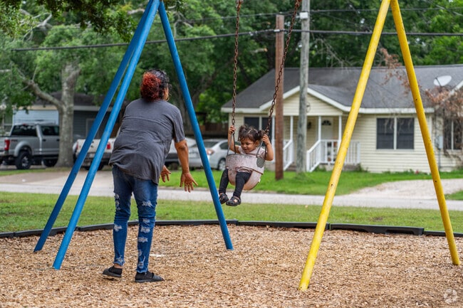 A mother and daughter enjoy the swing set at one of Alvin's many parks.