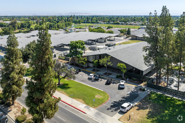 Tall pine trees stand at the entrance of Hoover High School in Fresno.