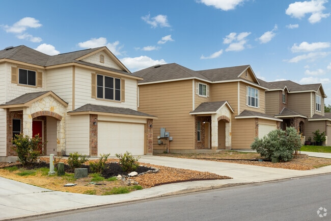 A row of traditional homes with wood siding and great garage space in Bulverde Village.