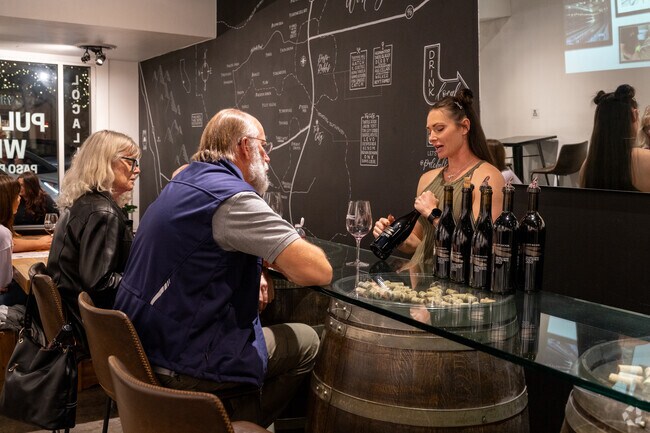 The hostess recommends a wine to customers at Pulchella Winery in Newhall.