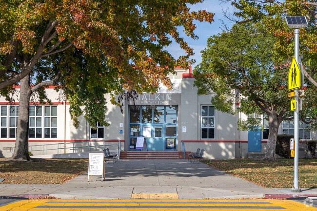 The entrance to Halkin Elementary School is surrounding by trees.