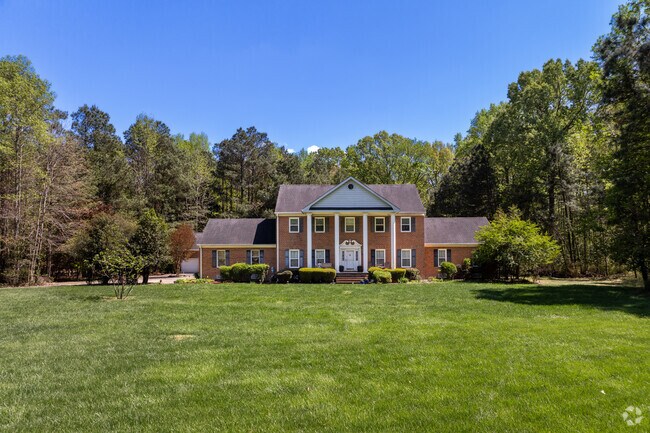 A colonial home in Caroon Farms sits on a large lot with a long, private driveway.