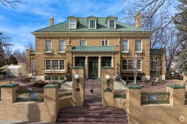 This stunning Georgian Revival home in Casper features a grand brick facade, green tile roof, and elegant columns that reflect classic architectural beauty.