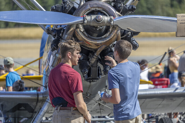 Spectators check out a motor on an old single engine prop plane at Bremerton Air Show in Gorst.
