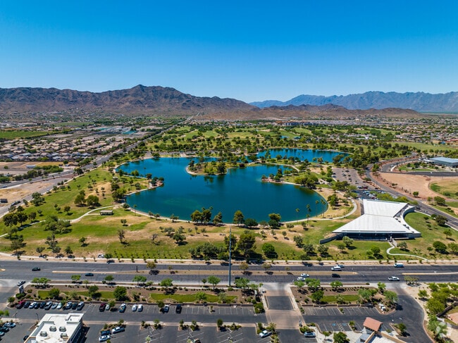 Captivating aerial view: Cesar Chavez Park's lake and South Mountain create a picturesque landscape in Laveen.