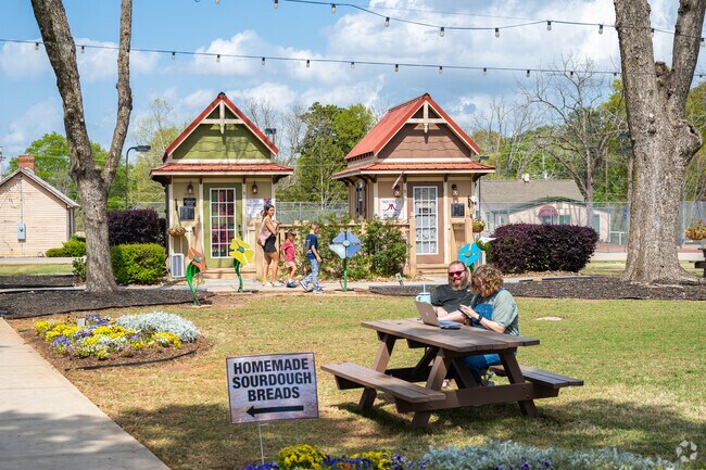 Whistlestop Park is surrounded by majestic pecan trees, their sprawling branches providing a cool and inviting shade during the sweltering summer days, creating an enchanting atmosphere as visitors stroll through the park and indulge in some delightful shopping.