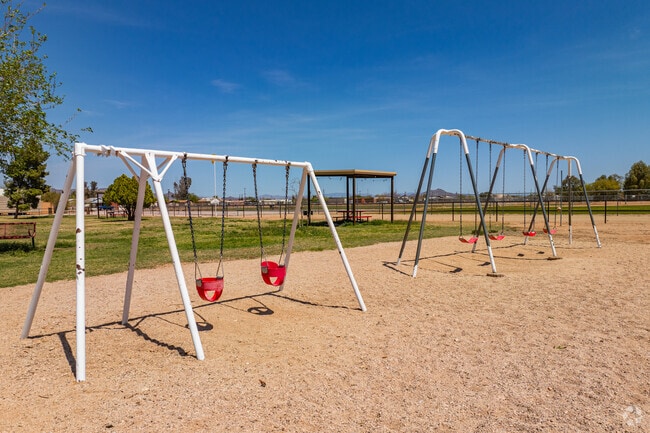 Families visiting Aguila Community Park enjoy swings designed for children of all ages.
