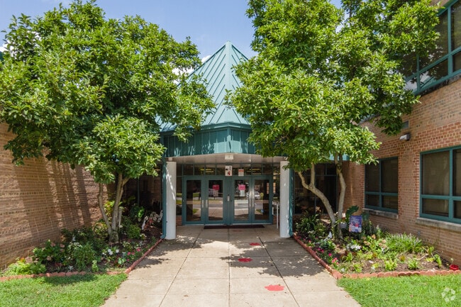 Natural trees encompass the entrance of the Columbia Elementary School in Annandale, VA.