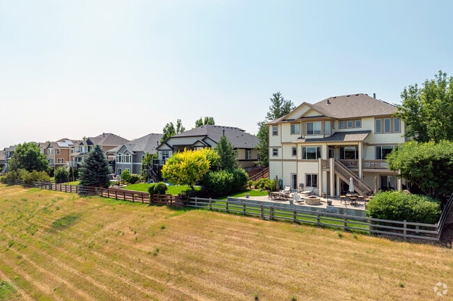 Much of the neighborhood is fenced off beside a paved trail lined with blue spruce trees.