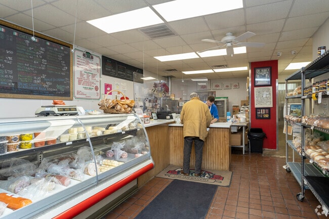 Inside of Orsi's Italian Bakery & Pizzeria with a resident ordering food.