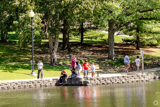 Exploring nature's wonders: kids happily playing with sticks in the pond at Lords Park.