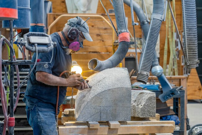 A resident sculptor carves a piece of granite at the Granite Museum near Graniteville.