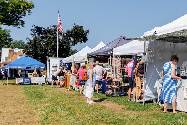 Locals browse vendor tents during the weekly Friday market at Edgewater Park in Williams Bay.