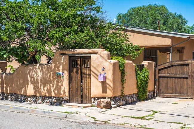 Many territorial style homes in West Guadalupe Historic sits behind stucco walls & wooden gates.