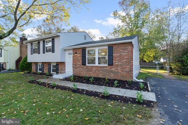 View of the house, driveway, and backyard fence.