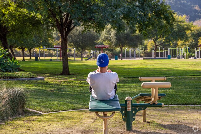 A hiker stopping to use one of many workout stations placed around the Orange Grove Park