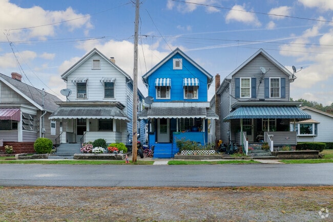 Historic homes line Kittanning streets, including a bright blue house with striped awnings.