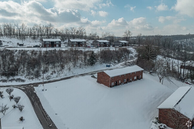 A row of homes on a hillside, overlooks a small apartment complex, in Summit.