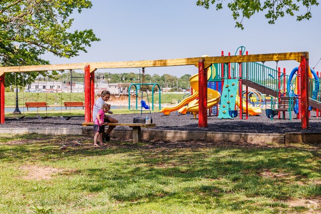 Residents enjoy the shade of a large tree at the Wonder Willa Playground.