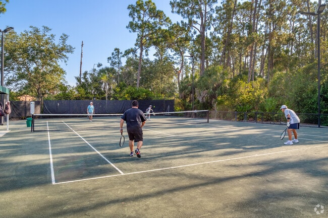 Residents playing tennis on one of 4 clay tennis courts.