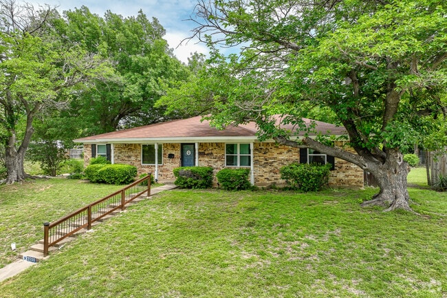 Luxurious one-story home in Richland Hills with manicured lawn.