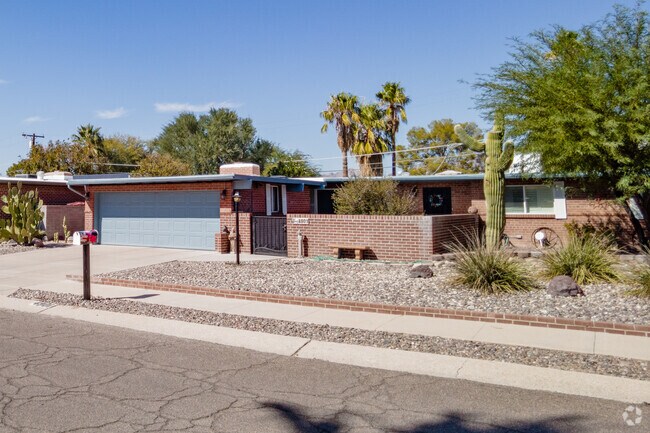 This brick flat roof home has a gravel yard in Glenn Heights Tucson.