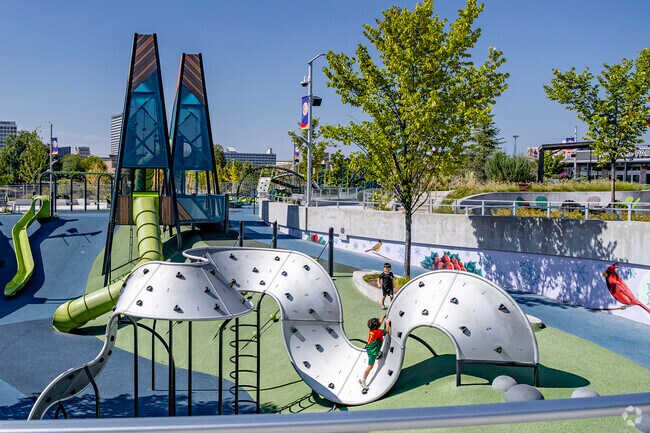 A ribbon-shaped play structure is surrounded by rubber padding at Howard Park's playground.