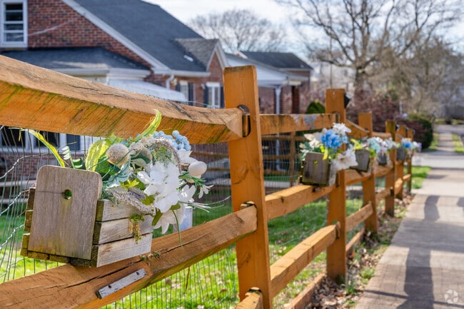 East End South residents hang flowers on wooden fencing to welcome spring.