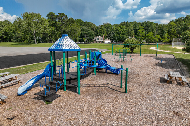 Playground with bench seating, and swings, for children to play on.