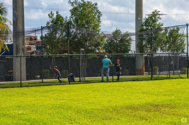 A father practices batting at the batting cages in Danny Meehan Recreational Field.