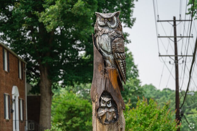A wood carved owl totem pole outside the Cheverly Community Center.