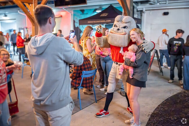 Families gather for photos with the UGA football mascot in Athens.